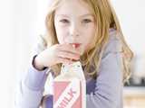 Girl drinking milk from a cardboard milk container. Levasil Colloidal Silica is used to enhance the frictional and printing properties of board stock.