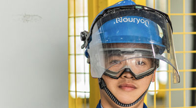 Nouryon employee in blue helmet and safety glasses