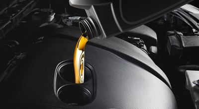 Pouring oil with lubricant additives into automotive engine