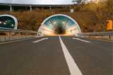 An asphalt road leading into a tunnel in a hill