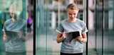 Young woman standing outside checking her tablet. Our products are essential in the production of semiconductors and are used in applications like solar cells, LEDs, smartphones and tablets. 