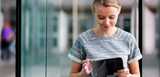 Young woman standing outside checking her tablet. Our products are essential in the production of semiconductors and are used in applications like solar cells, LEDs, smartphones and tablets. 