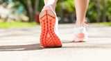 By walking showing bottom sole of a sports shoe
