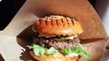 Burger in paper wrapper demonstrating barrier coating properties created by chemistry solutions