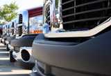 A row of several black car bumpers lined up