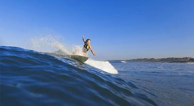 Young female surfer riding the wave