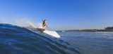 Young female surfer riding the wave