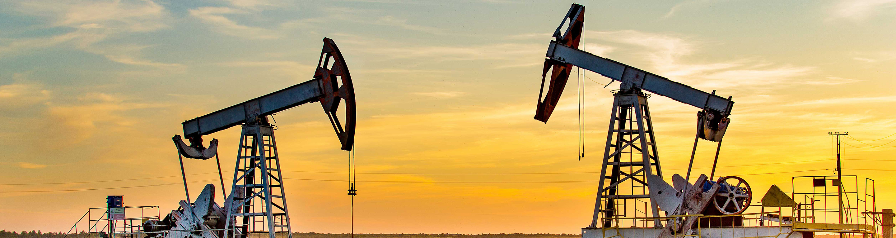 Two oilfield pumps at sunrise