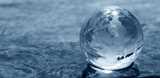 World map on a glass been over a liquid surface