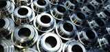Shiny silver color stainless steel parts background. Regular industrial metal production pattern. Nouryon offers aqueous cleaning chemical products for all metals such as steel, aluminum, brass, aerospace metals, and many others.