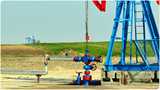 Land production site with pumpjack and wellhead