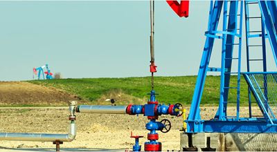 Land production site with pumpjack and wellhead