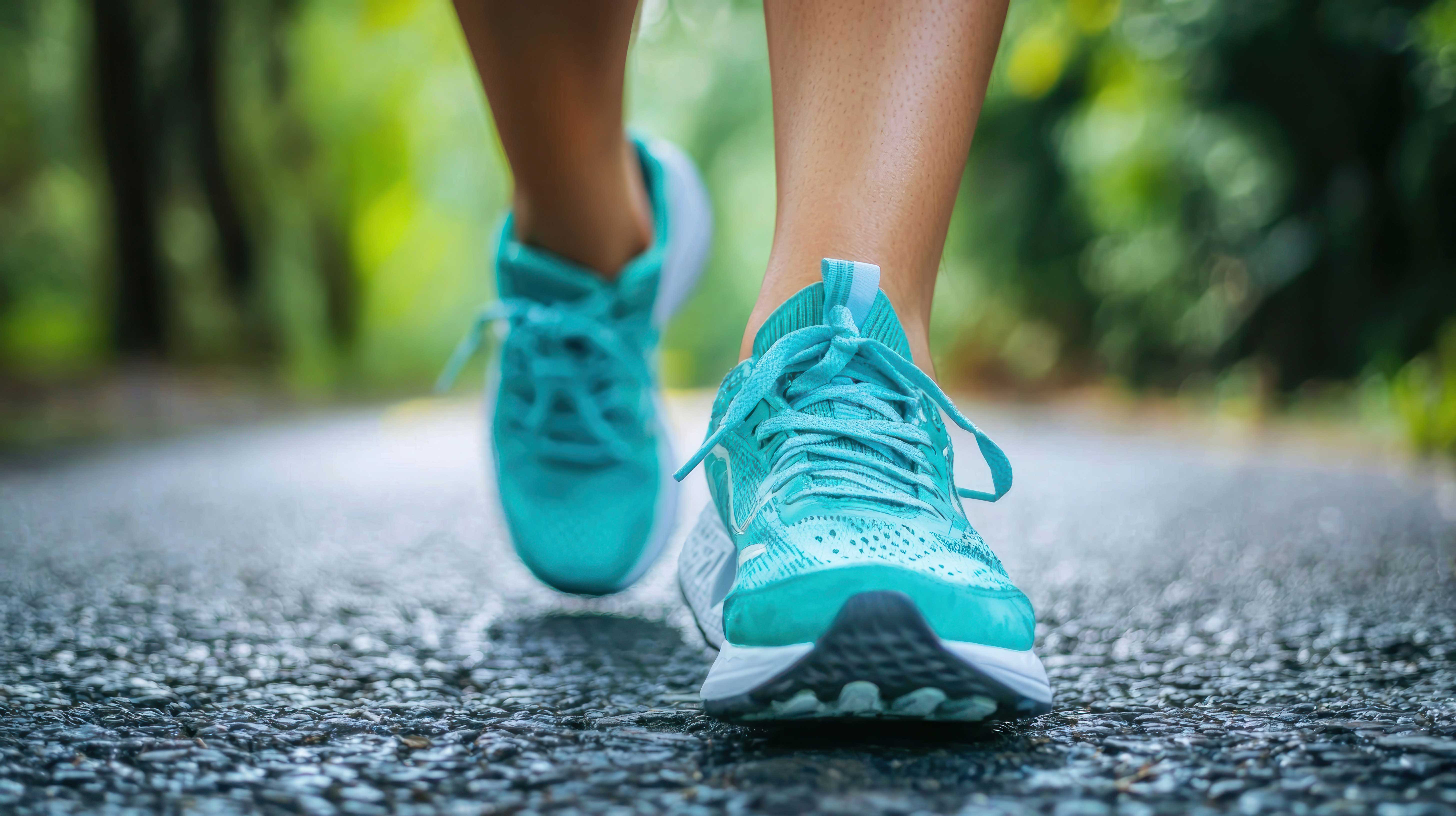 Aqua colored running shoes with forest at background