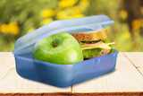 A blue lunchbox containing an apple and a sandwich