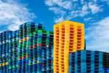 Colored crates stacked outside against a backdrop of a blue sky