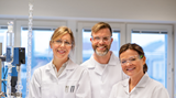 Three people in white laboratory coats