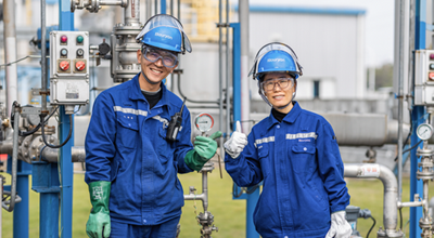 Two Nouryon employees wearing protective gear give thumbs up