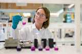 Female scientist with safety glasses looking at chemical substance